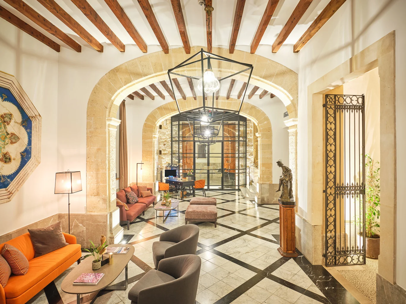 Empfangshalle des Hotel Gloria de Sant Jaume: Bögen aus Marès-Stein, Holzbalken und schachbrettartiger Marmorboden